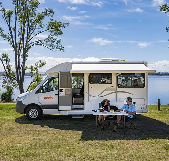 couple having a picnic next to a motorhome