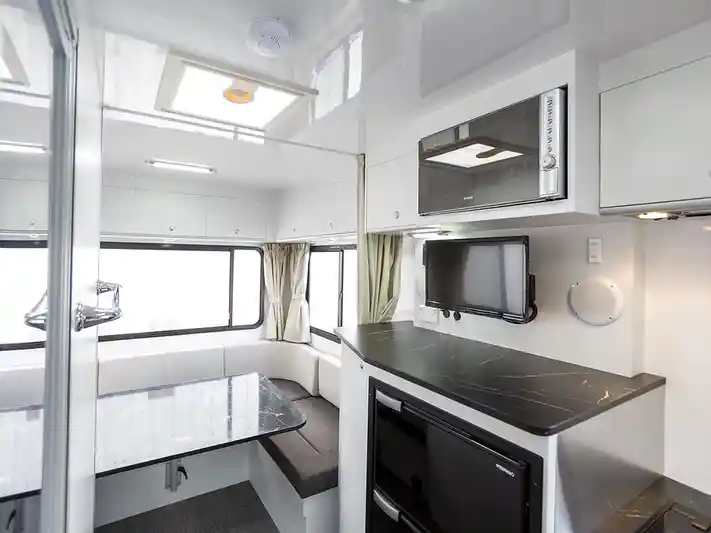 Cheapa 6 Berth Interior featuring a TV, Microwave, Kitchen and Bench